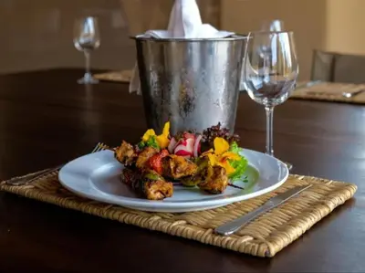 a plate of food on a table with a glass at Honeyguide Tented Safari Camps - Mantobeni in Manyeleti Game Reserve
