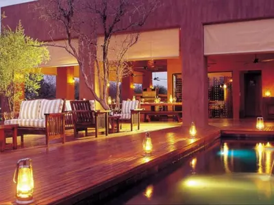 a patio with a pool and a deck with lights at Honeyguide Tented Safari Camps - Mantobeni in Manyeleti Game Reserve