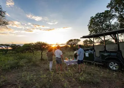 a group of people standing around a table in front of a vehicle at Finfoot Lake Reserve by Dream Resorts in Vaalkop Dam