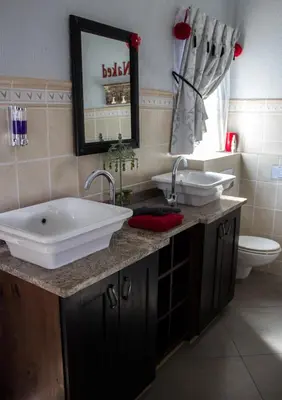 a bathroom with a tub and a sink and a toilet at Villa Too Kruger Lodge in Komatipoort