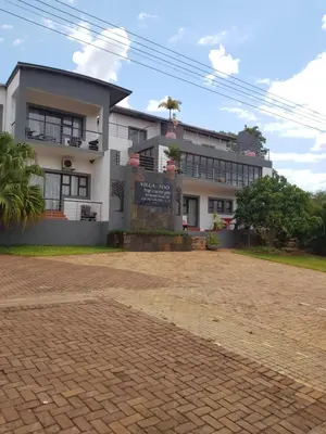 a building with a brick driveway in front of it at Villa Too Kruger Lodge in Komatipoort