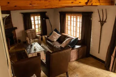 a living room with a couch and a table at Critchley Hackle - Managers Cottage in Dullstroom