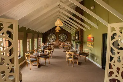 a dining room with tables and chairs and a chandelier at Critchley Hackle - Managers Cottage in Dullstroom