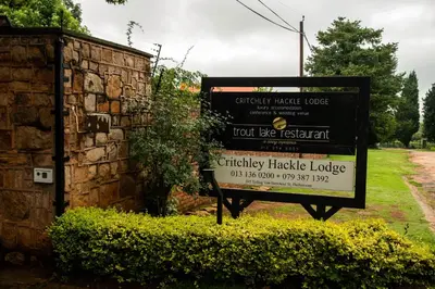 a sign in front of a stone wall at Critchley Hackle - Managers Cottage in Dullstroom