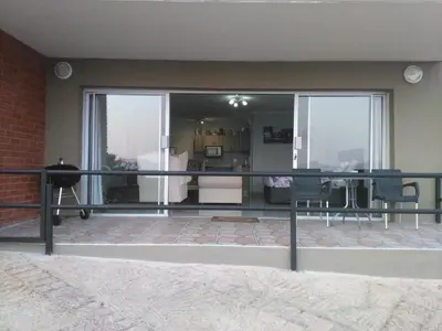 a balcony with a view of a living room at Thatch View in Hartbeespoort