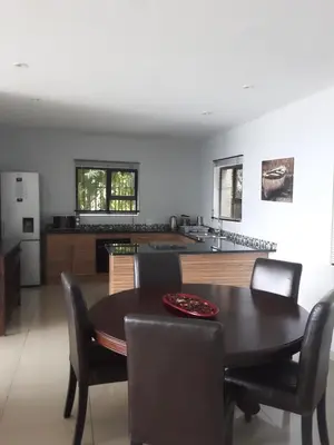 a kitchen and dining room with a table and chairs at Thatch View in Hartbeespoort