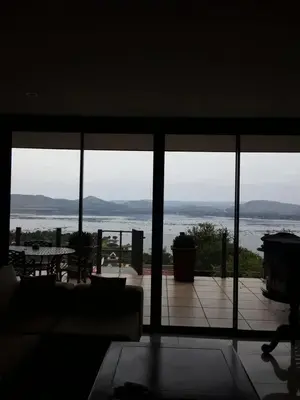 a living room with a view of the water at Thatch View in Hartbeespoort