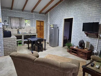 a living room with a couch and a kitchen at Numbi Hills Self-Catering in Hazyview