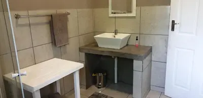 a small bathroom with a sink and a shower at Numbi Hills Self-Catering in Hazyview