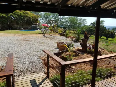 a pavilion with a bench and a garden at Numbi Hills Self-Catering in Hazyview
