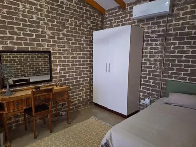 a bedroom with a desk with a computer and a bed at Numbi Hills Self-Catering in Hazyview