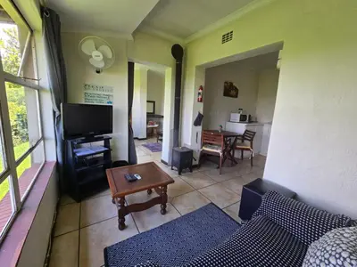 a living room with a couch and a table at Hills and Dales Accommodation in Lanseria