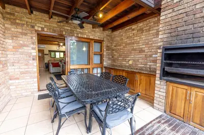 a patio with a table and chairs and a fireplace at Legend Safaris 257A - in Kruger Park Lodge in Hazyview