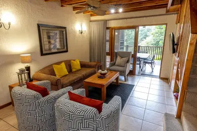 a living room with two couches and a table at Legend Safaris 257A - in Kruger Park Lodge in Hazyview
