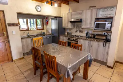 a kitchen with a table and chairs and a refrigerator at Legend Safaris 257A - in Kruger Park Lodge in Hazyview
