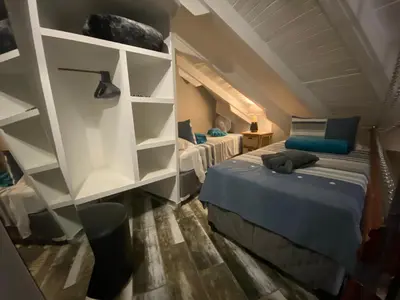 a bedroom with two beds and shelves in a room at Boomhuisie in Komatipoort