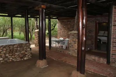 a brick house with a bath tub and a table at Jabula Kruger Safari Lodge in Marloth Park