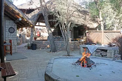 a fire pit in a patio with a table at Jabula Kruger Safari Lodge in Marloth Park
