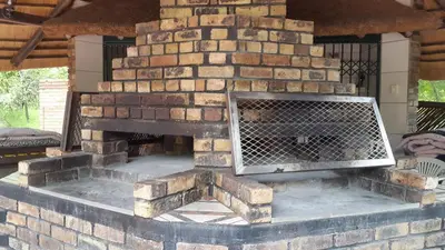 an outdoor brick fireplace with a fire place at Jabula Kruger Safari Lodge in Marloth Park