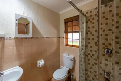 a bathroom with a toilet and a sink and a shower at Kruger Park Lodge Unit No. 543 in Hazyview