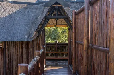 an entrance to a thatched building with a wooden fence at Kruger Park Lodge Unit No. 543 in Hazyview