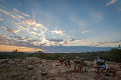a group of people sitting in chairs on top of a mountain at Rukiya Safari Camp in Hoedspruit