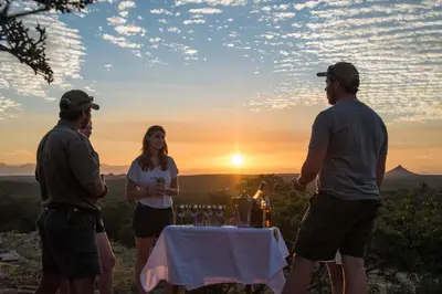 a group of people standing around a table with wine glasses at Rukiya Safari Camp in Hoedspruit