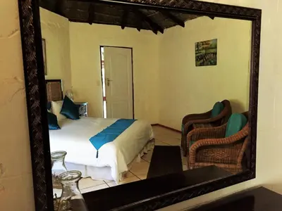 a mirror in a bedroom with a bed and a chair at ConcordiaVOC in Lanseria