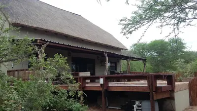 a house with a wooden deck in front of it at Marloth Kruger Whispering Ants in Marloth Park