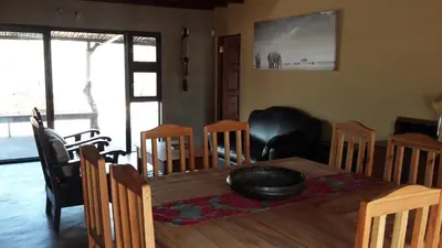 a dining room with a wooden table and chairs at Marloth Kruger Whispering Ants in Marloth Park