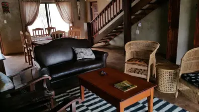 a living room with a leather couch and a table at Marloth Kruger Whispering Ants in Marloth Park