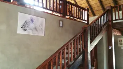a staircase with a picture of a lion on the wall at Marloth Kruger Whispering Ants in Marloth Park