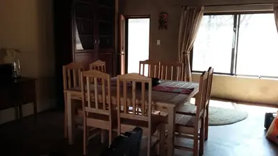 a dining room with a wooden table and chairs at Marloth Kruger Whispering Ants in Marloth Park
