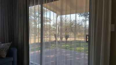 a sliding glass door with a view of a yard at Crimson Bush Lodge in Klipdrift