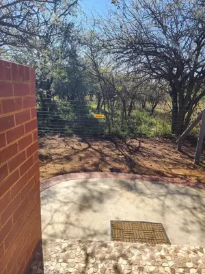 a patio with a brick wall and a stairway at Crimson Bush Lodge in Klipdrift