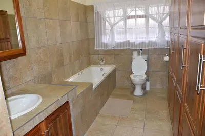 a bathroom with a sink and a toilet and a tub at Stoep At Steenbok Self Catering in Komatipoort