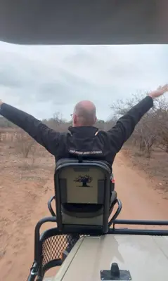 a man sitting in a chair with his arms outstretched at The Baobab Bush Lodge and Villa in Hoedspruit