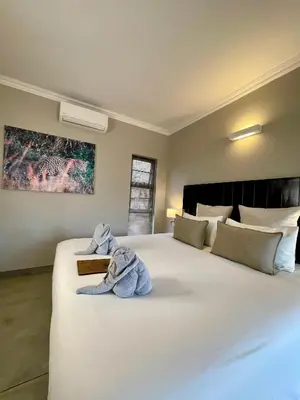 a bedroom with a large white bed with a towel on it at The Baobab Bush Lodge and Villa in Hoedspruit