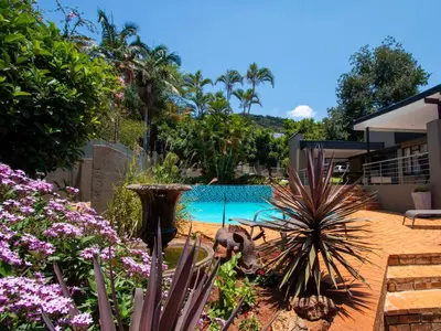 a backyard with a swimming pool and some flowers at Casa Albergo Corporate Guest House in Pretoria