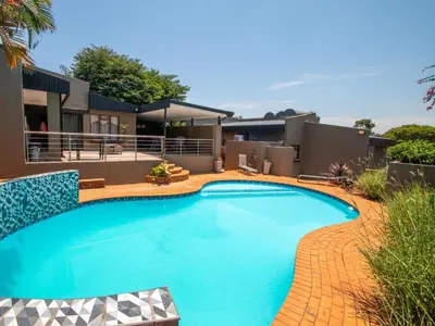 a swimming pool in front of a house at Casa Albergo Corporate Guest House in Pretoria