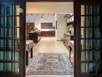 a room with a library with a table and a rug at Casa Albergo Corporate Guest House in Pretoria