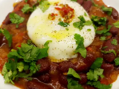 a poached egg on top of a bowl of chili at umSisi House in White River