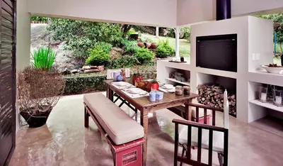 a dining room with a table and chairs and a television at umSisi House in White River