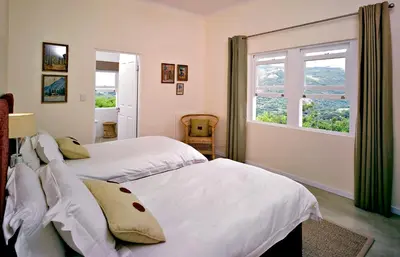 two beds in a bedroom with a window at umSisi House in White River