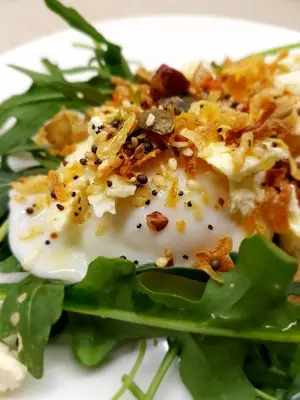 a plate of food with a egg on top of lettuce at umSisi House in White River