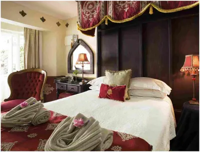 a bedroom with a large bed and a chair at De Ark Guest House in Lydenburg