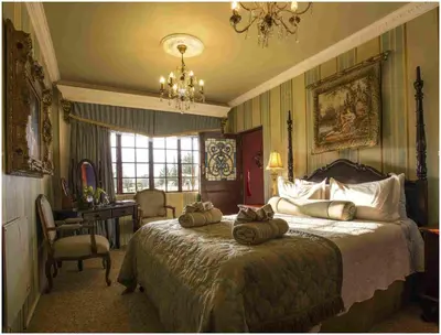 a bedroom with a bed with three pillows on it at De Ark Guest House in Lydenburg