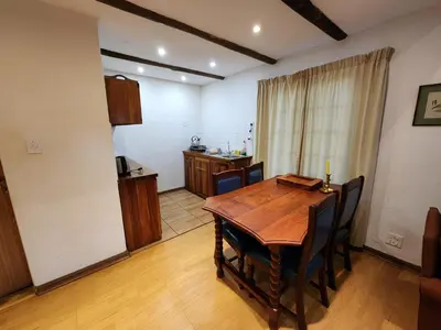a dining room with a wooden table and chairs at Softwaters Guesthouse Cottages in Louis Trichardt
