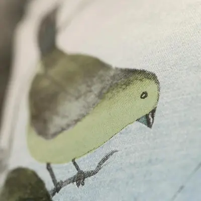 a green bird sitting on the side of a book at The Aviary in Pretoria