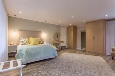 a bedroom with a large bed with yellow pillows at The Aviary in Pretoria